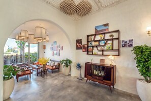 A spacious living area with a large arched doorway, a wooden cabinet, and a variety of wall-mounted decorations. - Hidden 5BR Pool Villa - 8' Walk to An Bang Beach (Đà Nẵng)