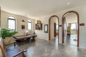 A spacious room with a dining table, chairs, and a bench. There are arched doorways leading to other areas. - Hidden 5BR Pool Villa - 8' Walk to An Bang Beach (Đà Nẵng)
