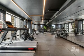 Ett modernt gym med konditionsutrustning, styrketräningsmaskiner och kettlebells.