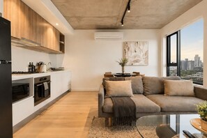 Een modern appartement met keuken, woonruimte en een groot raam met uitzicht op de stad.
