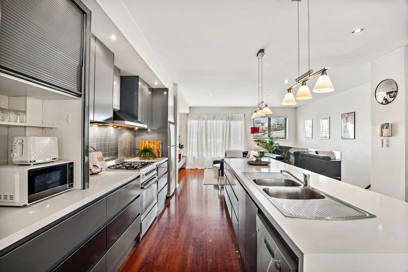 A modern kitchen with stainless steel appliances, a central island, and pendant lighting.