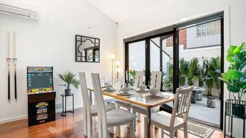 A dining area with a table set for four, a pool table, and a large window with a view of the outdoors.