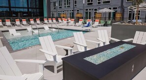 A pool area with lounge chairs and a water feature. - Landing | Chic 1BD, Clubhouse, Gym (Durham)