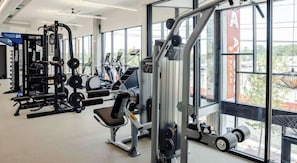 A gym with various exercise equipment, large windows, and a view of the outdoors. - Landing | Incredible Studio, Gym, Clubhouse (Durham)