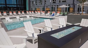 A pool area with lounge chairs and a water feature. - Landing | Incredible Studio, Gym, Clubhouse (Durham)