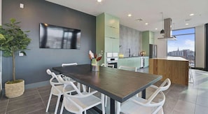 A modern kitchen with a dining area, a large window, and a city view. - Landing | Incredible Studio, Gym, Clubhouse (Durham)