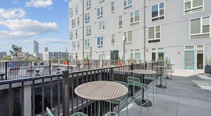 A rooftop terrace with outdoor seating and a view of the city skyline. - Landing | Stylish Studio, Clubhouse, Gym (Durham)