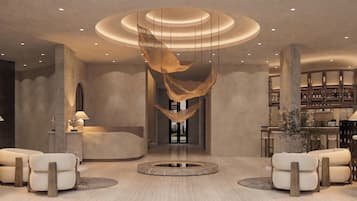 A modern lobby with a central seating area, a reception desk, and a bar with shelves of bottles.
