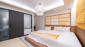 Un dormitorio moderno con una cama grande, puerta corredera de vidrio y una lámpara en el techo.