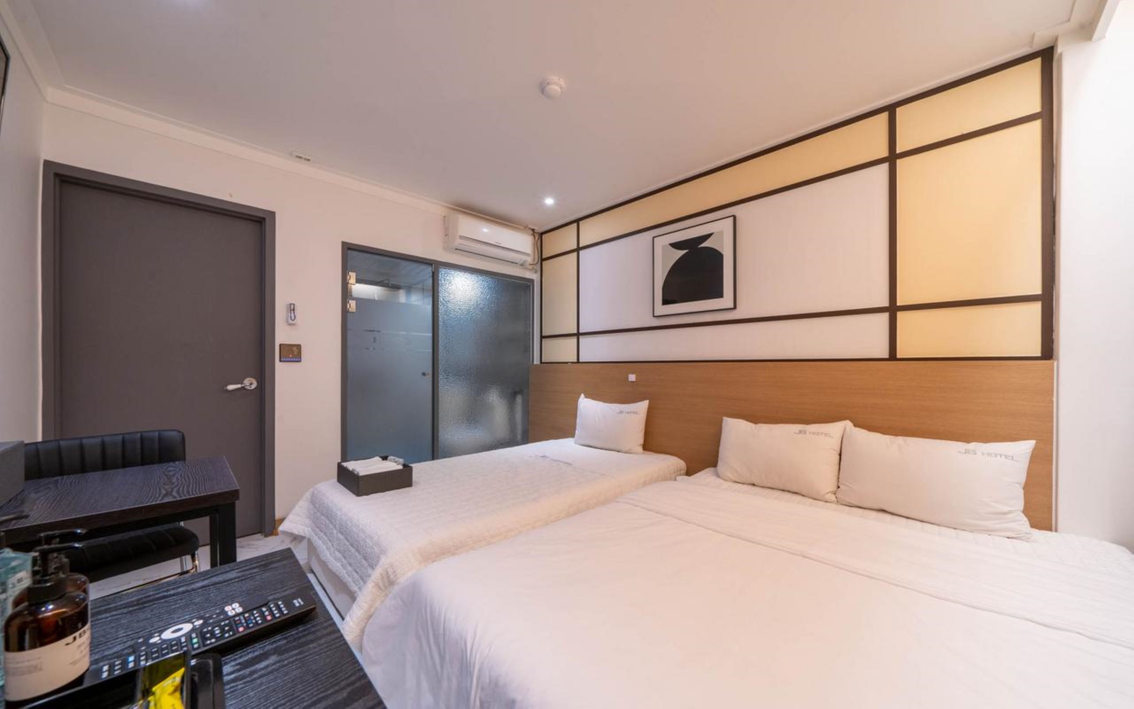 Una habitación de hotel con dos camas, un escritorio y una silla.