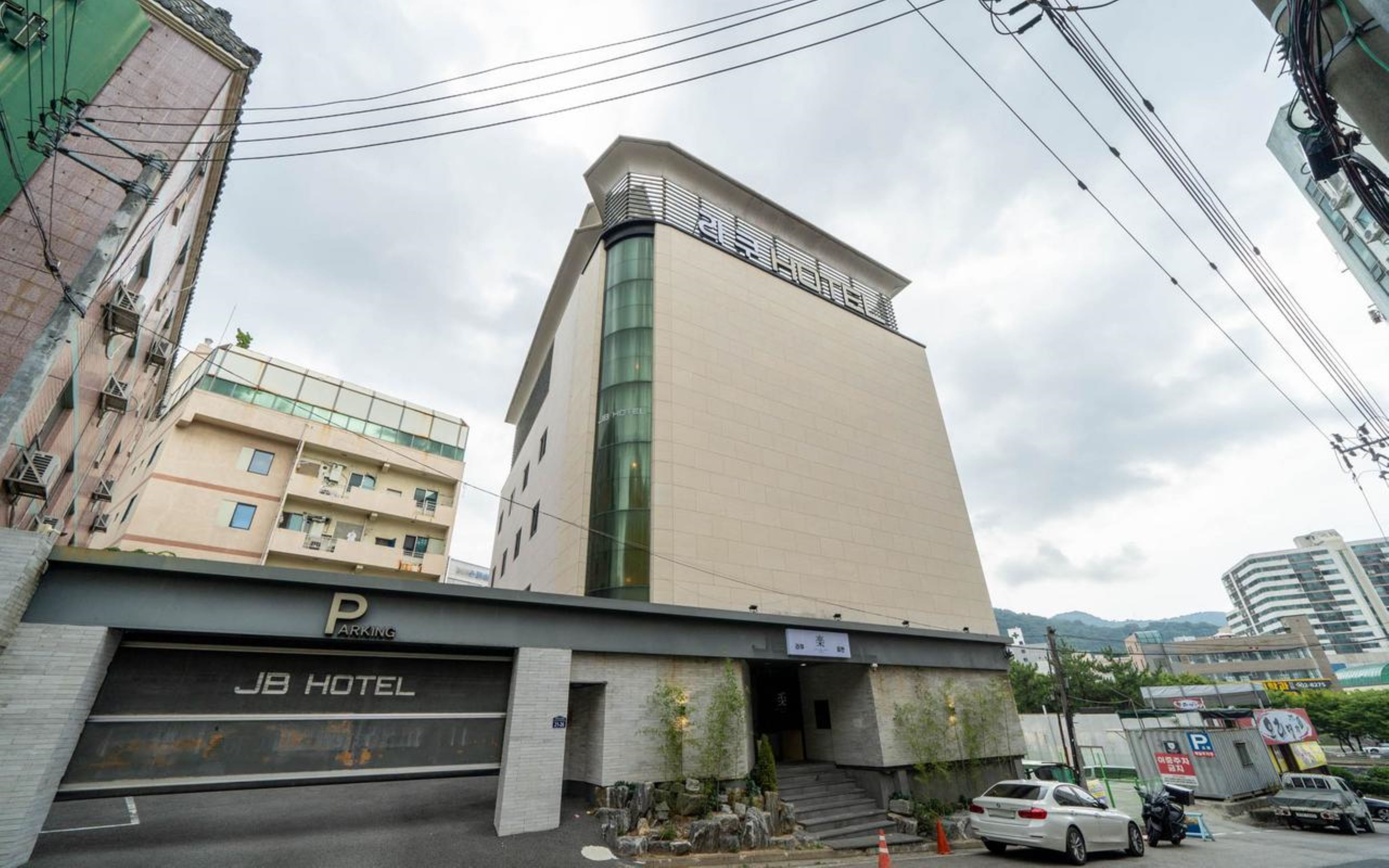 Un hotel con diseño moderno, un aparcamiento y una escalera que lleva a la entrada.
