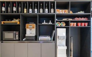 Zona cuina amb diversos electrodomèstics, com ara un microones, una cafetera i un frigorífic.