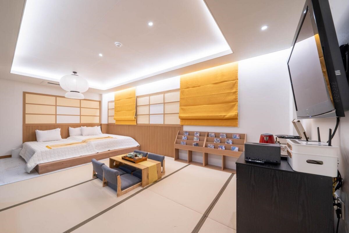 Una habitación de hotel moderna con cama, zona de estar y televisor.