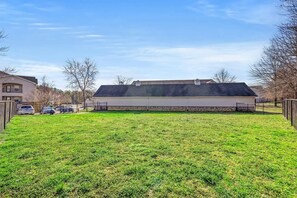 A residential property with a large grassy yard, a garage, and a two-story building with a flat roof. - Landing | Beautiful 2BD, Clubhouse, Gym (Chattanooga)