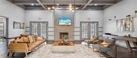 A spacious living room with a fireplace, a sofa, a coffee table, and a painting on the wall.