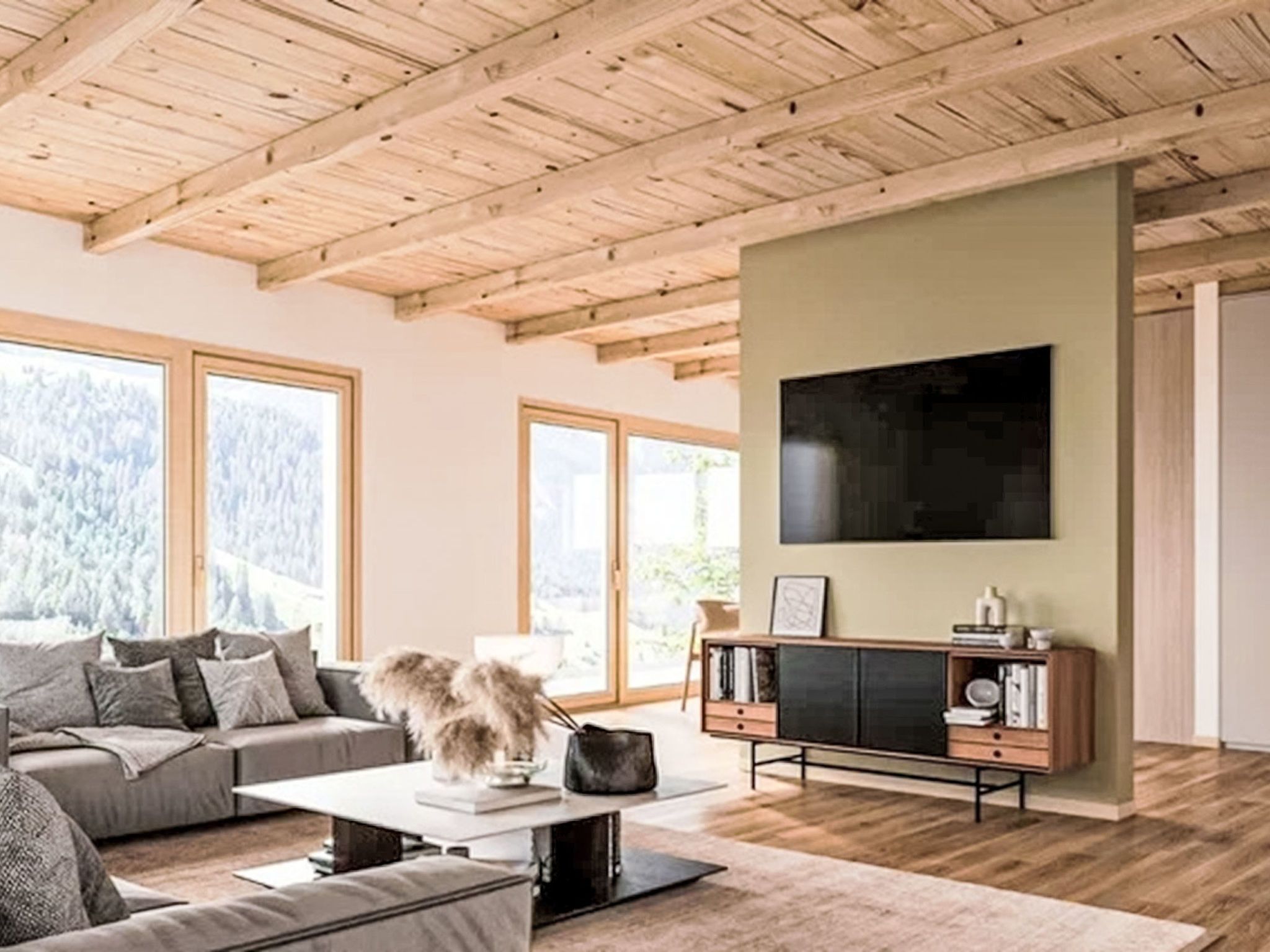 A modern living room with a wooden ceiling, large windows, a sofa, a coffee table, and a flat-screen TV mounted on the wall.