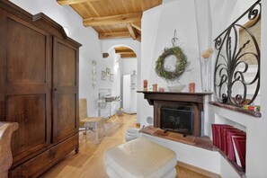 A traditional interior with a wooden cabinet, a fireplace, and a hanging wreath. - Borghetto La Borra & Borretta (Serramazzoni)