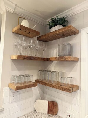 A kitchen with wooden shelves holding wine glasses, jars, and a plant. - Lafayette Hills 3BR Private Family Getaway Near Walnut Creek (Lafayette)