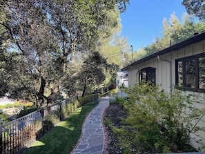 A stone pathway leading to a house with a black metal fence on one side and a tree-lined driveway. - Lafayette Hills 3BR Private Family Getaway Near Walnut Creek (Lafayette)