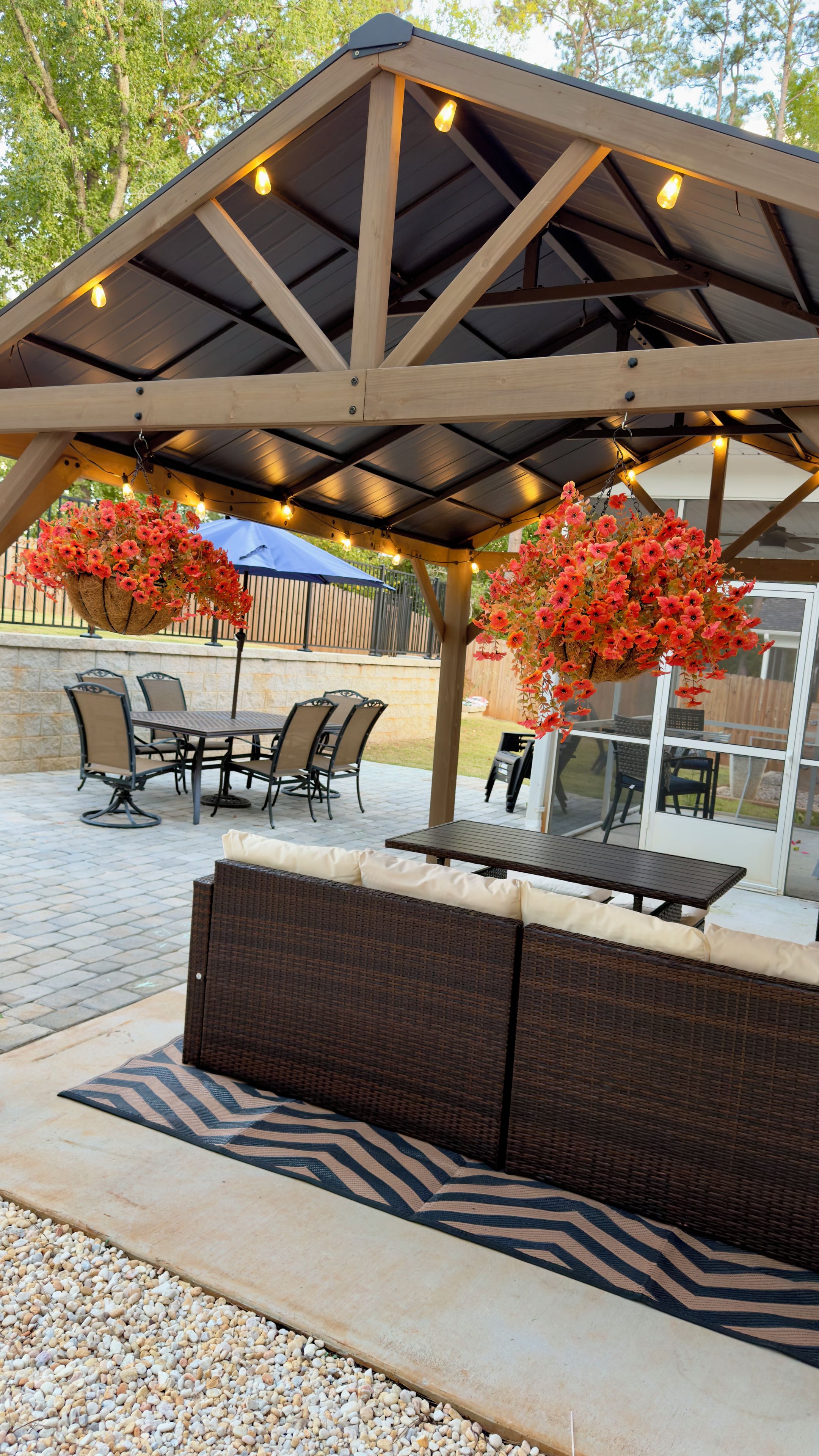 Une terrasse extérieure dotée d’un espace salon couvert, d’une table et de chaises.