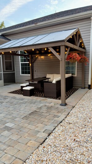 An outdoor patio area with a covered seating arrangement and a pergola with string lights. - Walk to Shops & Restaurants - 6BR in Heart of Downtown Lexington (Lexington)