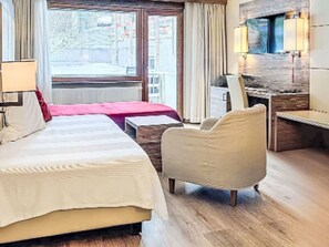 A hotel room with a bed, a desk, a chair, and a TV mounted on the wall. - Entre Ciel et Terre by Interhome (Verbier)