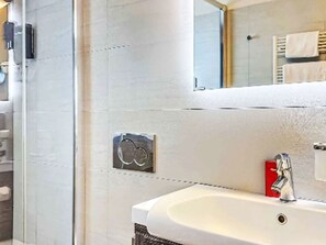 A bathroom with a white sink, a mirror, and a towel rack. - Entre Ciel et Terre by Interhome (Verbier)
