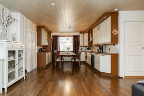 Une cuisine moderne avec des meubles en bois, une table à manger et une vue par la fenêtre.