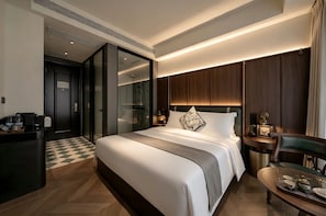 A modern hotel room with a large bed, a desk with a computer, and a bathroom with a shower. - Relanding Hotel Zhuhai Gongbei Port (zhuhai)