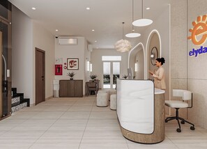 Una zona d'arribada moderna amb un taulell de forma corba, una sala d'espera amb cadires i un mostrador de recepció visible.