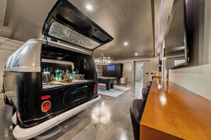 A compact living space with a kitchenette, a pool table, and a flat-screen TV. - Luxe | Pool, Sauna, & Karaoke | Sleeps 16 (Garland County)