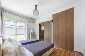 Une chambre à coucher avec un lit, une armoire et une fenêtre.