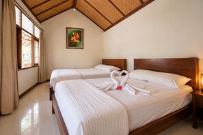 Habitación de hotel con dos camas, techo de madera, un cuadro en la pared y una ventana con cortinas.