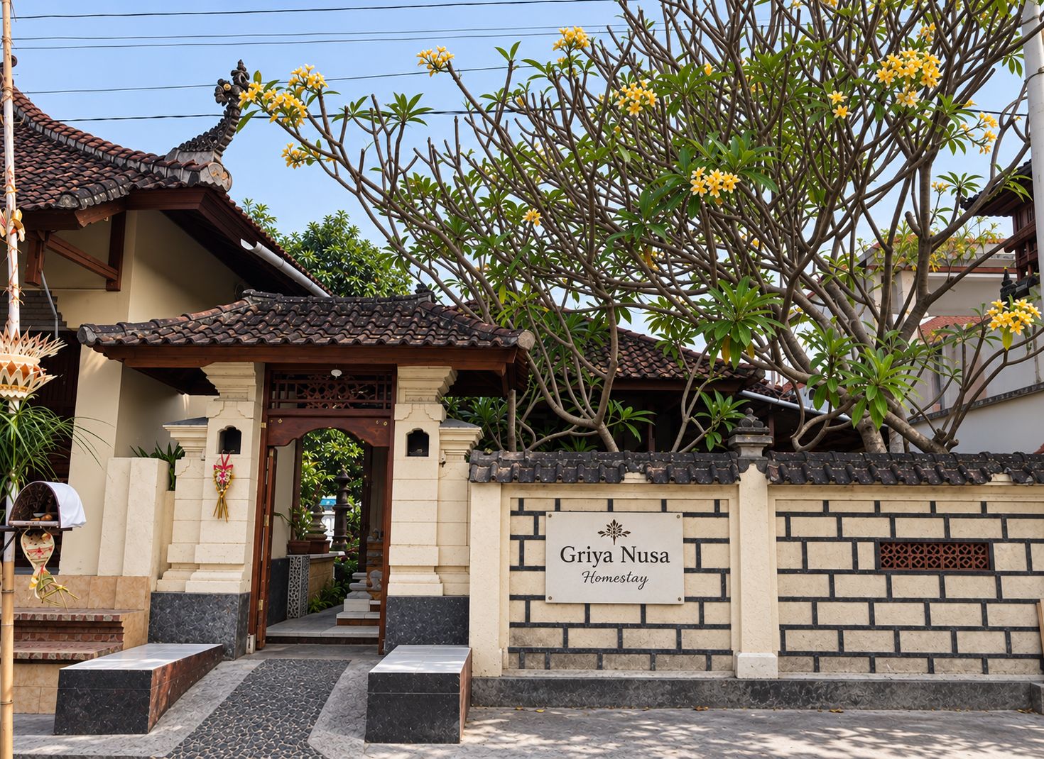 Un bâtiment traditionnel avec un toit en tuiles et une enseigne indiquant « Griya Nusa Homestay ».