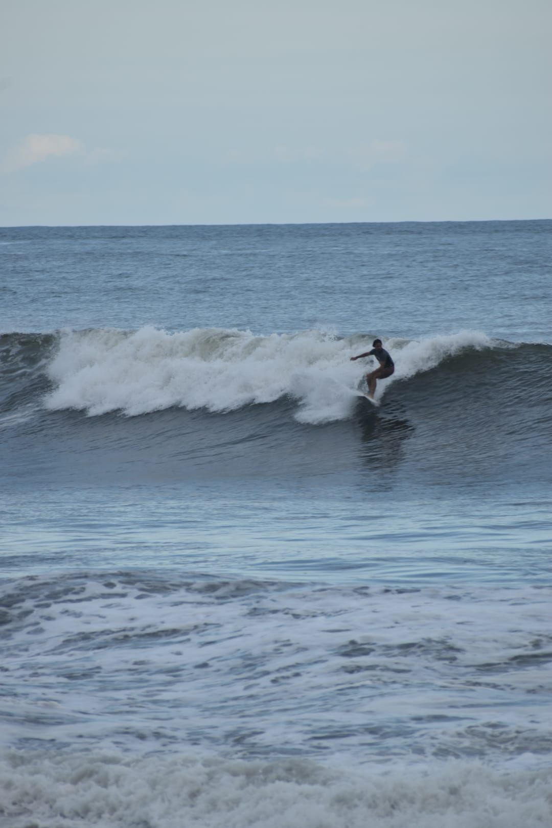 A person surfing on a wave in the ocean.