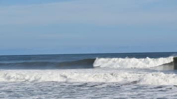 A beach with waves and a clear sky.