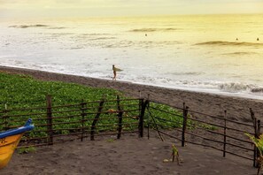 Una playa con una valla de madera y un bote.