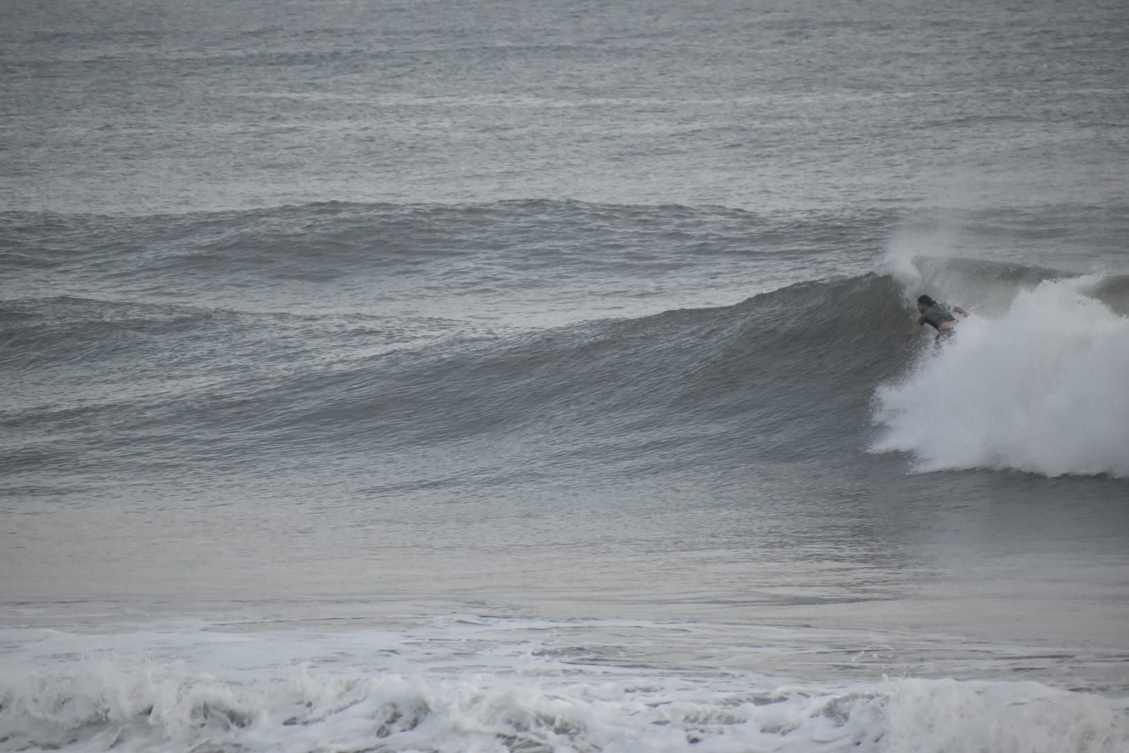 Un surfista montando una ola grande en el océano.