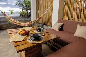 A wooden table with a woven placemat, a bowl of fruit, and a glass of water. - Vrbo Property (Mizata)