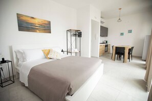 Un dormitorio con cama, mesita de noche y un cuadro en la pared.
