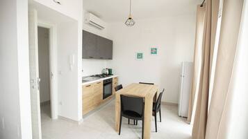 Une cuisine moderne avec une table et des chaises, un réfrigérateur et une cuisinière.