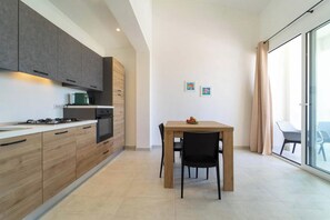 Una cocina moderna con comedor, que incluye estufa, horno y armarios.