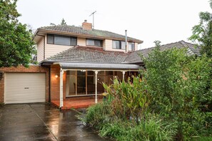 A two-story house with a covered porch and a garage. - StayAU Spacious 2-Story Retreat & Easy City Access (Mont Albert North)