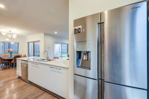 A modern kitchen with a stainless steel refrigerator, a built-in water dispenser, and a dishwasher. - StayAU Luxury Double-Story Home | A/C Throughout (Clyde)