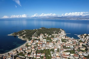 An aerial view of a coastal town with a mix of residential buildings and a small island with dense greenery. - House in Kassiopi village, 400m from sea (Kassiopi)