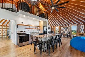 Een ruime loft met een keuken, eethoek en een groot bed.