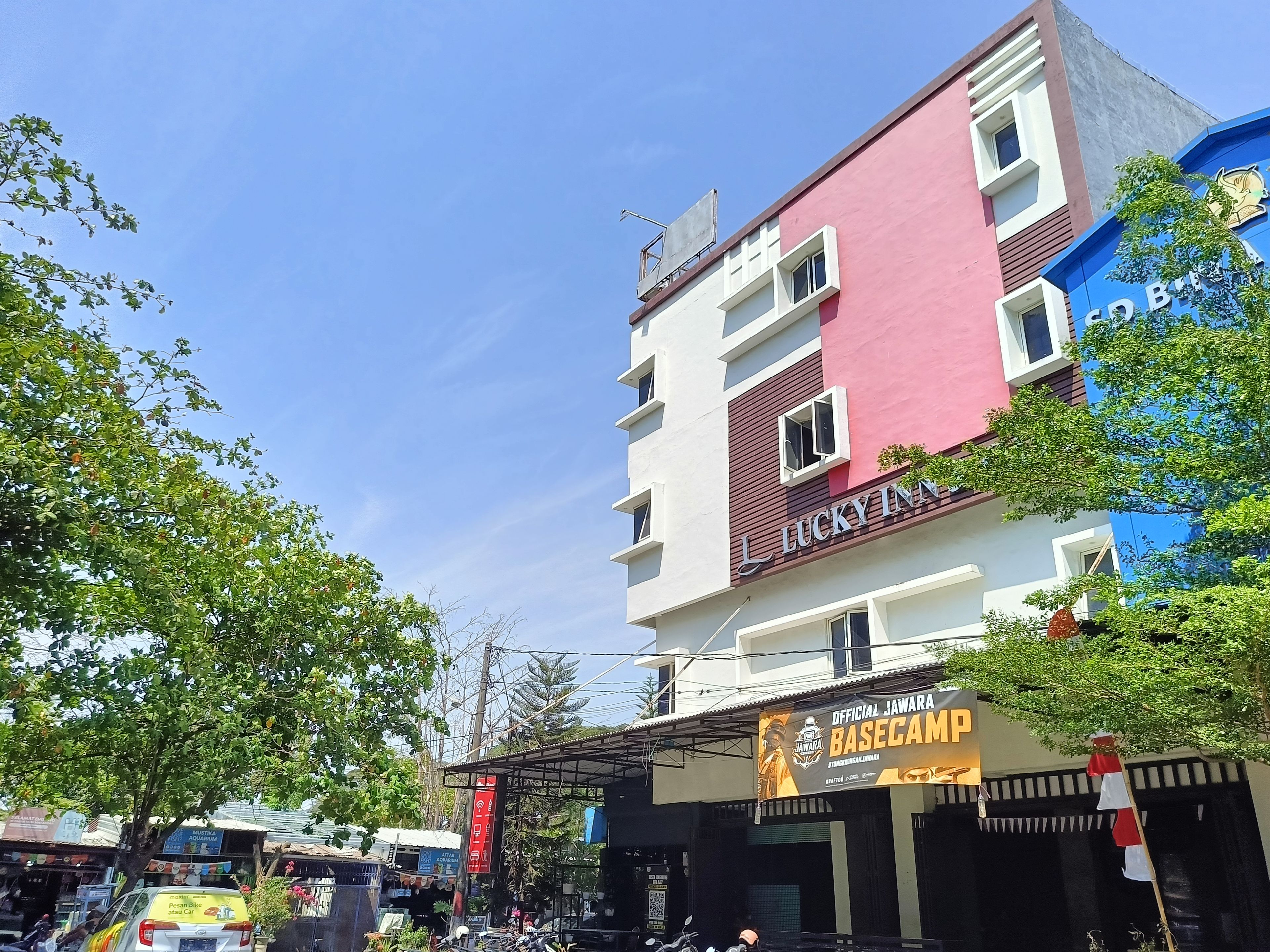 A multi-story building with a sign for 'Lucky Inn' and a banner for 'Official Jawara Basecamp.'