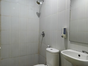 A bathroom with a toilet, a sink, and a shower. - Hotel O near Mall Panakkukang (Makassar)