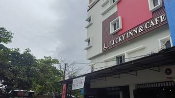 A multi-story building with a sign for 'Lucky Inn & Cafe' on the facade.