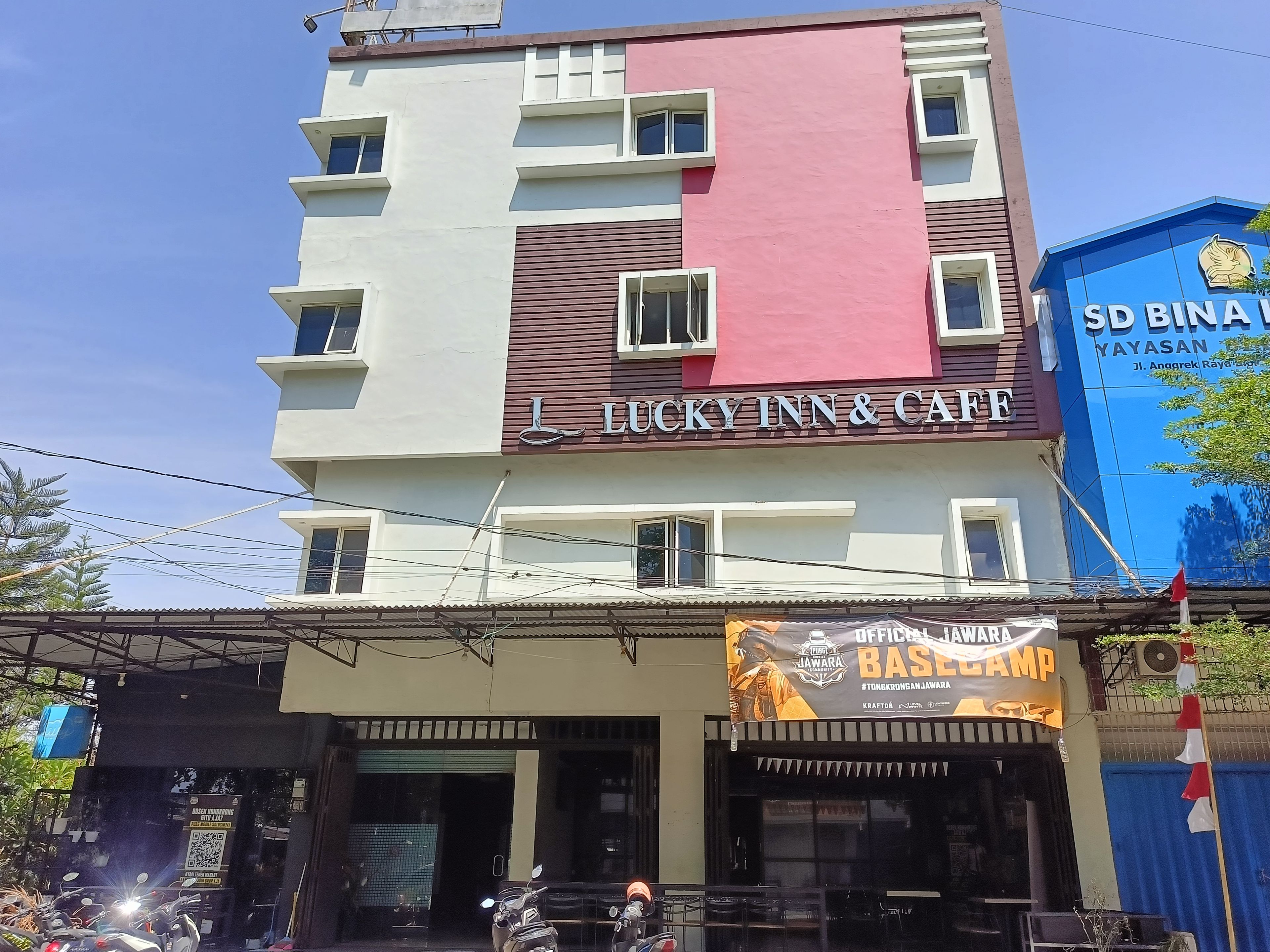 A multi-story building with a prominent sign for 'Lucky Inn & Cafe' on the facade.